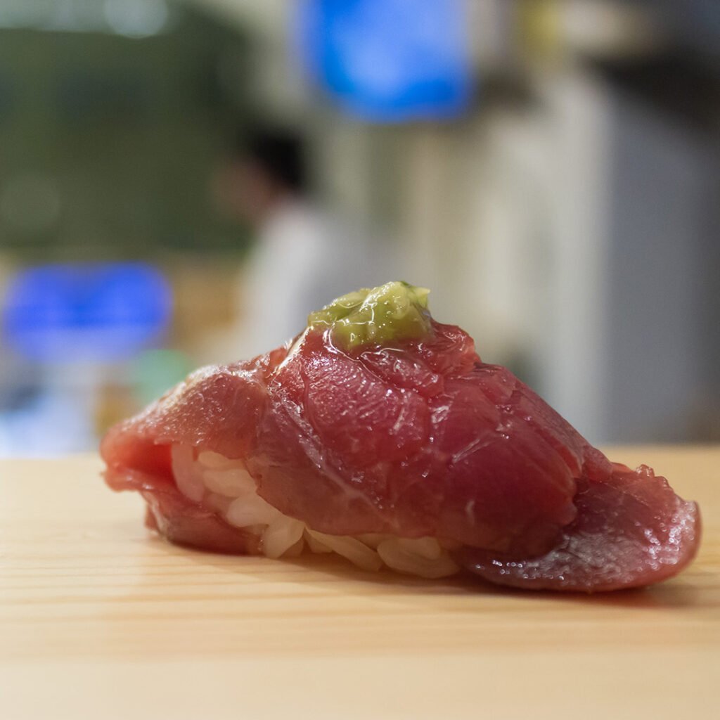 Nigiri de atún con wasabi sobre la barra de madera