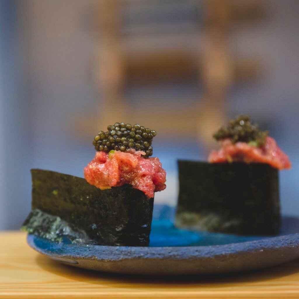 Gunkan de atún con caviar sobre plato de cerámica azul